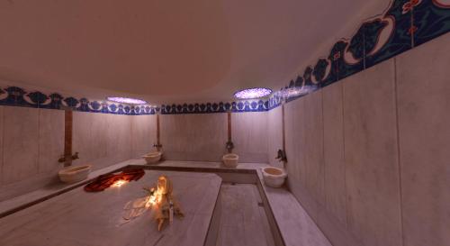 a bathroom with two toilets and a fire in the floor at Anitas Hotel in Konaklı