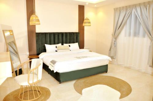 een slaapkamer met een groot bed en een stoel bij Msakn Aldar in Abha