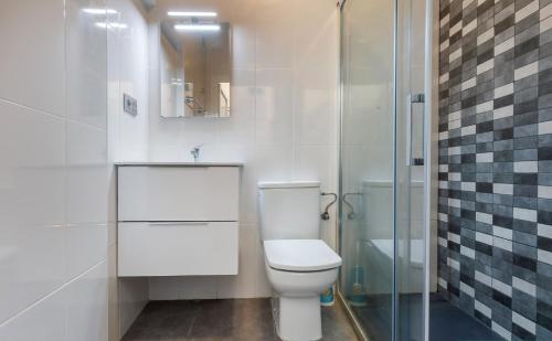 a bathroom with a toilet and a glass shower at Casa Centro Histórico Almería - Jayrán in Almería