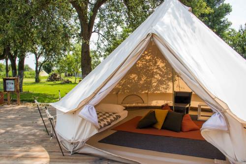 a white tent with a bed in a park at BELLTENT SAVICA in Zagreb