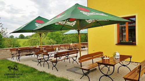 a group of tables and chairs with umbrellas at Zámecký Dvůr Černousy in V Poli