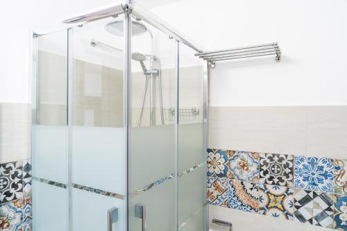 een glazen douche in de badkamer met tegels op de muur bij Casa Siria in Balestrate