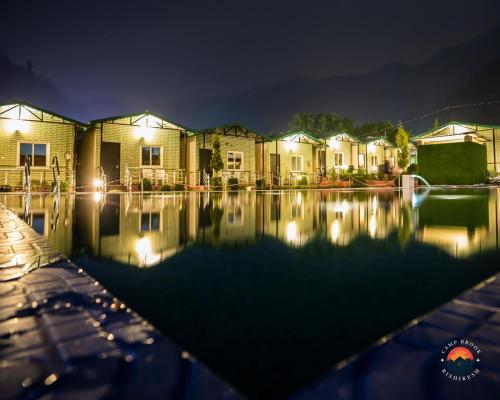 a row of houses at night with a swimming pool at Camp Brook - Luxury Camping in Rishikesh in Rishīkesh
