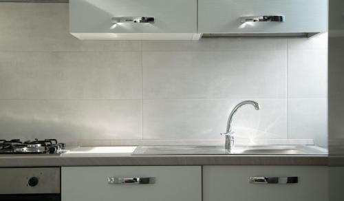 a white kitchen with a sink and a stove at I SUONI DEL MARE in Porto San Giorgio