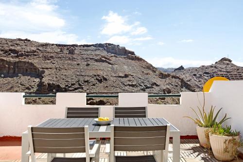 a table and chairs on a patio with a view of a mountain at Suite On the Beach in Playa del Cura