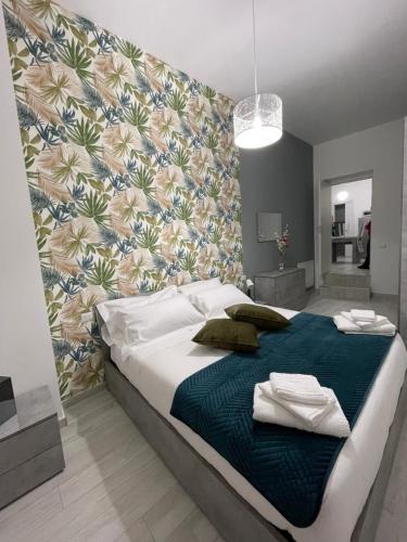 1 dormitorio con 1 cama grande y pared de flores en Arcaroli Borgo Vico "La casetta" en Vico del Gargano