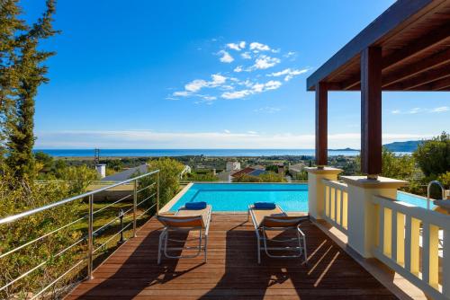 卡拉索斯的住宿－Aegean Blue Villa's - All Inclusive & Water park，一个带椅子的甲板和一个游泳池