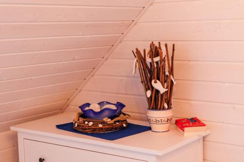 a table with a basket and a vase with sticks at Dom Wakacyjny Baltic Home & Dom Baltic Home Garden Inn in Zastań