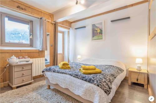 a bedroom with a bed with yellow towels on it at CHAMBRE INDÉPENDANTE avec SALLE DE BAIN INDÉPENDANTE au RDC d un chalet à 25 kms Chamonix in Saint-Gervais-les-Bains