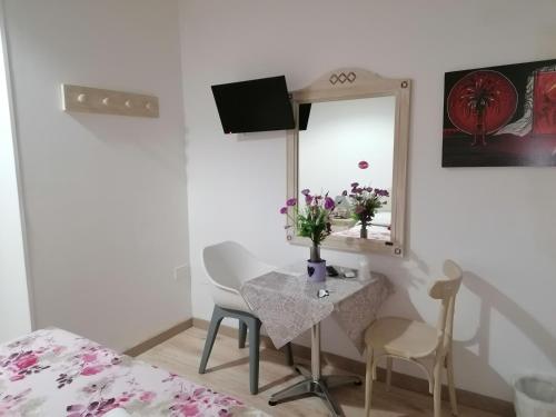 una camera con tavolo, specchio e letto di Cicerone Guest House a Firenze