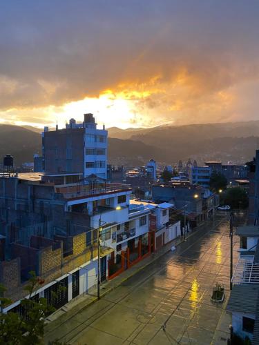 a view of a city with the sunset in the background at La Casa de Zarela in Huaraz