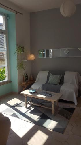 a living room with a couch and a coffee table at Appartement dans maison de charme Doullens in Doullens