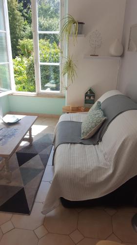 a bedroom with two beds and a table and windows at Appartement dans maison de charme Doullens in Doullens