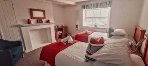 a bedroom with two beds and a fireplace at Itchenor Sailing Club in Chichester