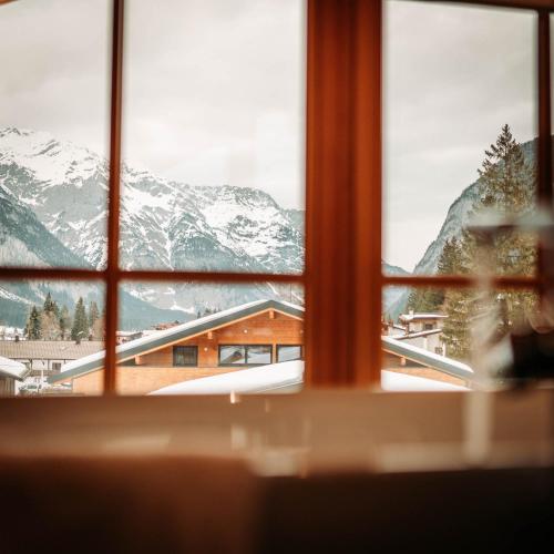 a view of a snowy mountain from a window at IM WEIDACH Superior Chalets in Leutasch