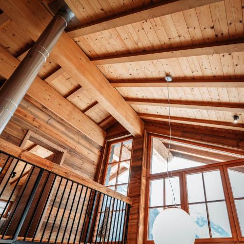 a room with wooden ceilings and windows in a house at IM WEIDACH Superior Chalets in Leutasch