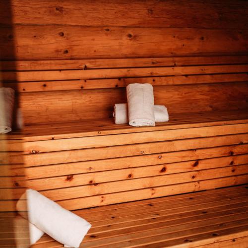 a wooden wall with rolled towels in a sauna at IM WEIDACH Superior Chalets in Leutasch