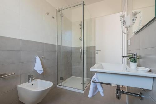 a white bathroom with a sink and a shower at Casole Living B&B in Copertino