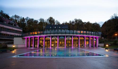 Un bâtiment avec éclairage violet devant lui dans l'établissement Les Violettes Hotel & Spa, à Jungholtz
