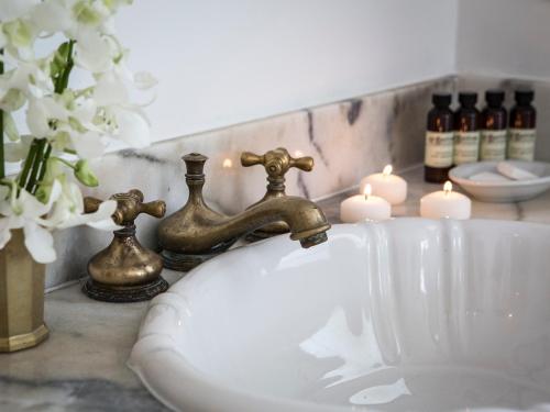 a bathroom sink with a faucet and candles on a counter at Casa Faena Miami Beach in Miami Beach