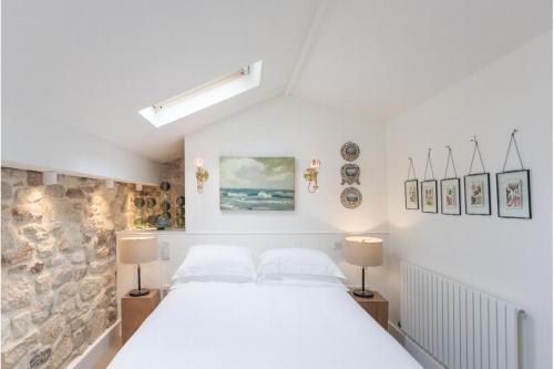 a bedroom with a white bed and two lamps at Antonia's Pearls in St Austell