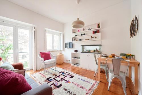 a living room with a table and a tv at Sunny Renovated Apt With AC, By TimeCooler in Lisbon