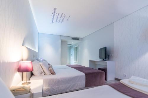 Un pat sau paturi într-o cameră la Costa de Prata Hotel