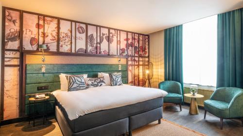 a hotel room with a bed and a chair at Hotel Indigo Brussels - City by IHG in Brussels