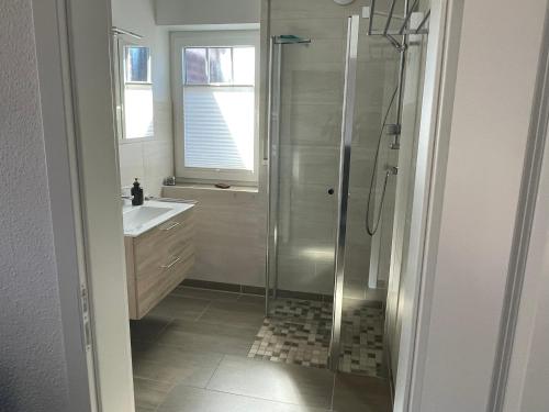 ein Badezimmer mit Dusche und Waschbecken in der Unterkunft Südwester in Dornumersiel