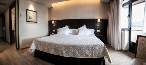 a bedroom with a large bed with white sheets and pillows at Montemar in Llanes
