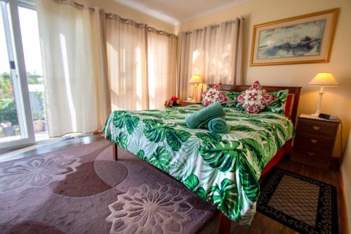 a bedroom with a large bed with a green bedspread at TryOver in Meningie