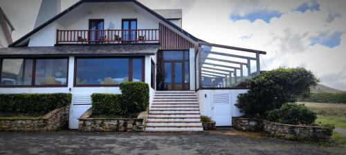 a white house with stairs and a balcony at As Garzas in Barizo