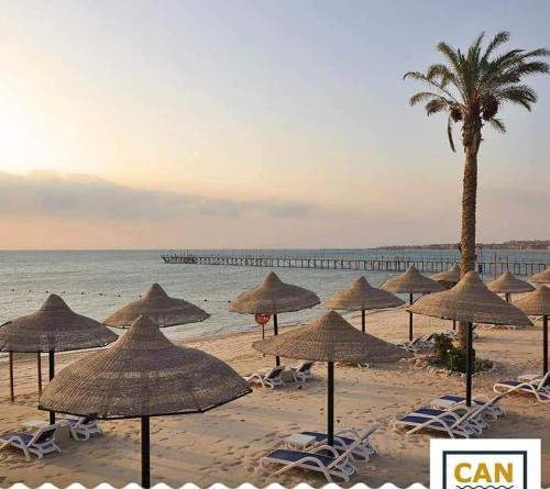 a group of umbrellas and chairs on a beach at Stella Di Mare Ain Sokhna Beautiful Luxurious Villa in Ain Sokhna