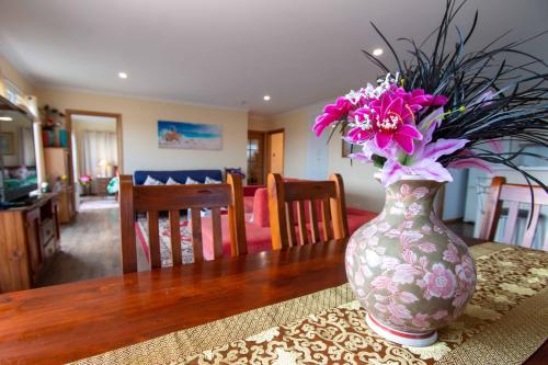 a vase with pink flowers sitting on a table at TryOver in Meningie