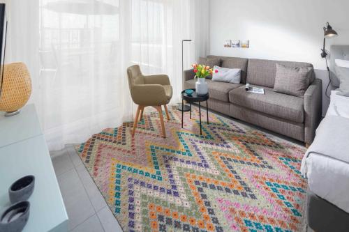 a living room with a couch and a colorful rug at WestStrandBlick in Norderney