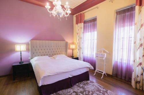 a bedroom with a white bed and a chandelier at Kastello Hotel in Nafplio