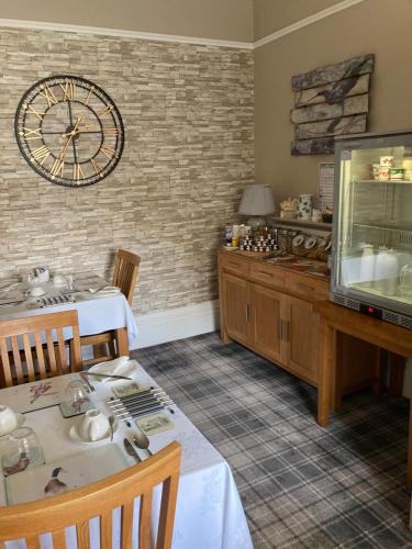a dining room with a clock on the wall at Thornsgill House Bed & Breakfast in Askrigg