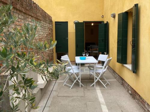 een patio met een tafel en stoelen en een gebouw bij Appartamento Tre Archi con corte privata in Venetië