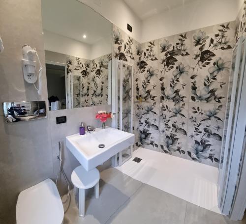 uma casa de banho com um lavatório, um chuveiro e um WC. em Hotel Charly em Milão