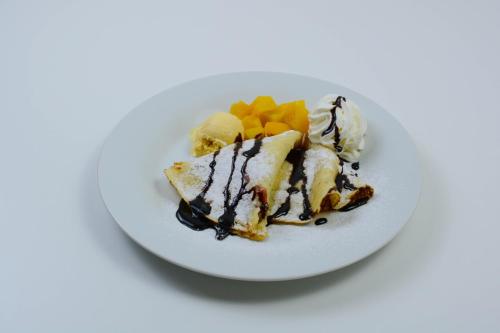 a white plate with a piece of cake and ice cream at Hotel ILF in Prague