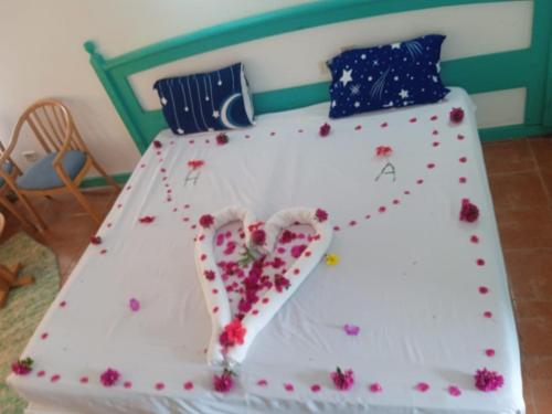 a white bed with red flowers on it at Badawia Sharm Resort in Sharm El Sheikh