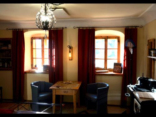 a dining room with red curtains and a table and chairs at Appartement Kleiner Monde in Weinberg