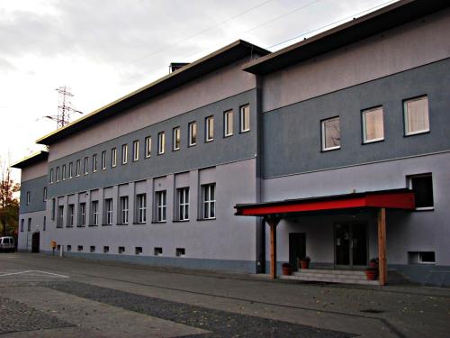 a large gray building with a red awning at City Apartments Protos in Knurów