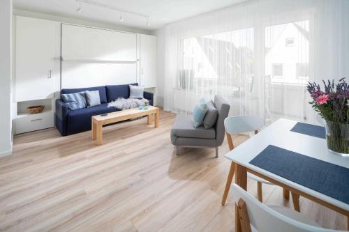 sala de estar con sofá azul y mesa en 53 Nord, en Norderney