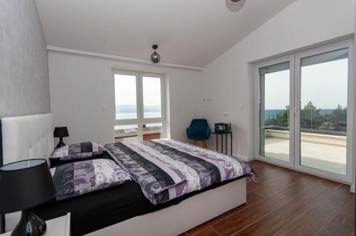 a bedroom with a bed and a large window at Villa M&M in Stanići