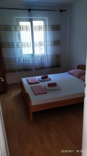 1 dormitorio con 1 cama blanca grande y 2 ventanas en Apartman Felicija, en Prigradica