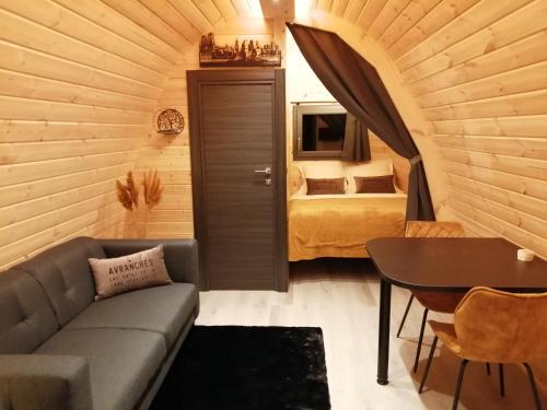 sala de estar con sofá y cama en una habitación en Le Domaine de Pivette Chambre climatisée et insolite avec terrasse privative en Avranches