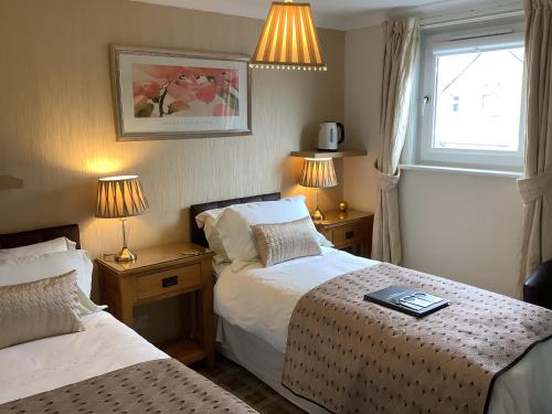 Habitación de hotel con 2 camas y ventana en Silverstrands, en Inverness