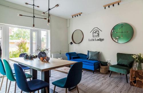 ein Wohnzimmer mit einem Tisch und blauen Stühlen in der Unterkunft Lubi Lodge in Balatonboglár
