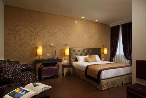 ヴェネツィアにあるアルカディア ブティック ホテルのベッドと椅子付きのホテルルーム